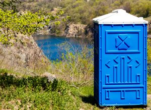 portable toilet next to a river outdoors