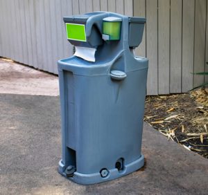 Hand wash station next to a wooden shed